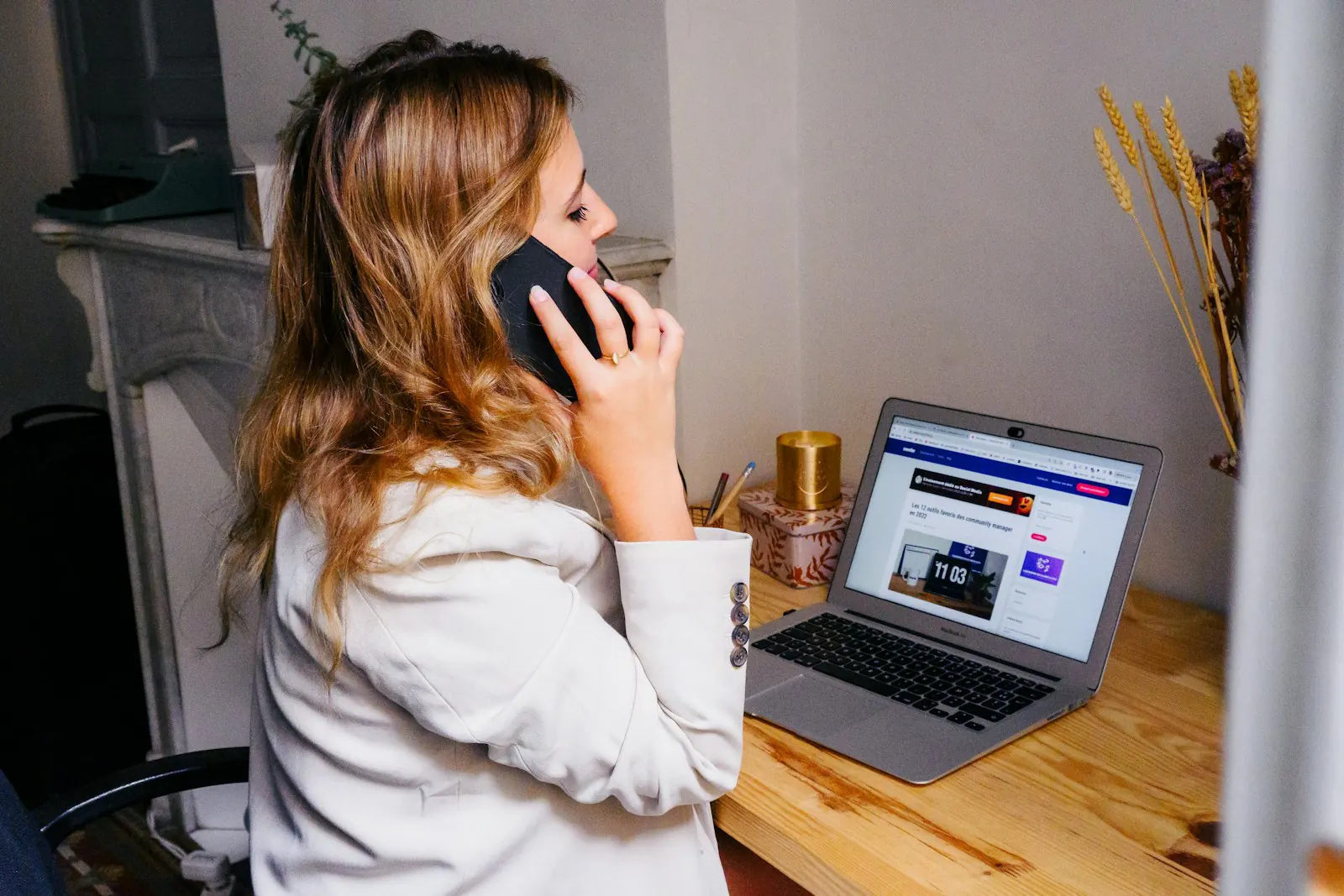 A receptionist on the phone at a desk with a laptop