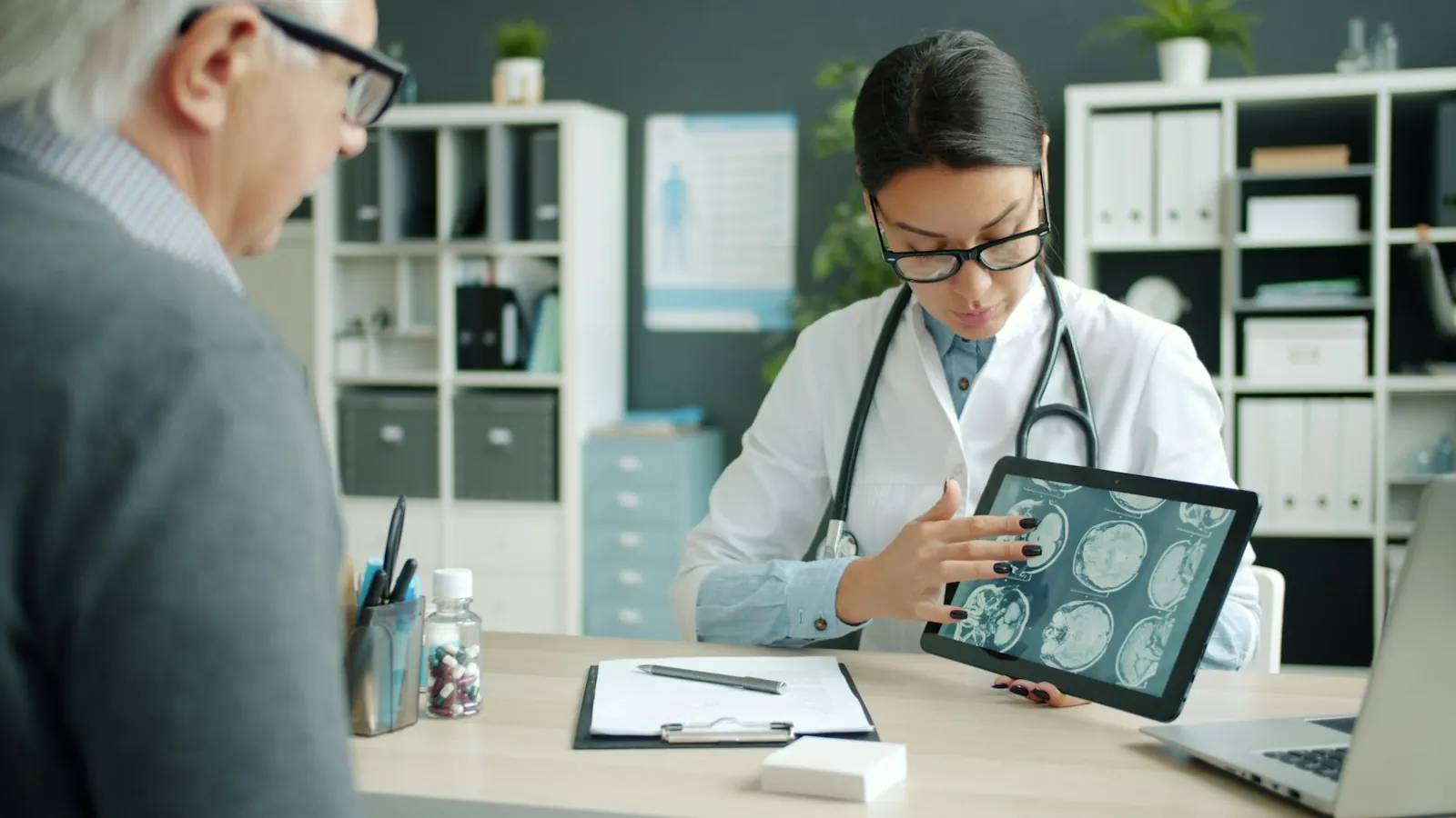 A specialist showing scan results to a patient on a tablet