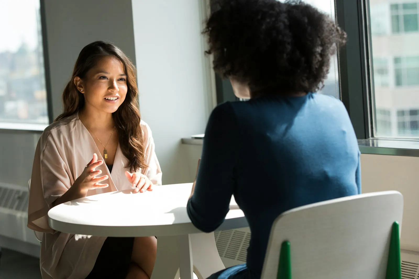 A coach talking with a client at a small table