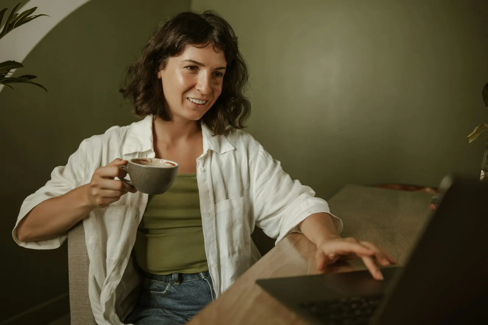 A coach smiling on a video call at her desk